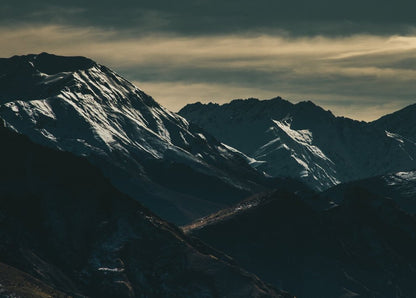 Moody Snowy Peaks Under Storm Clouds