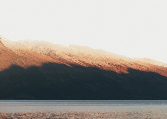 Shadowed Mountain Ridge Above Lake