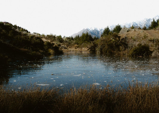 Frozen Alpine Pond and Distant Peaks