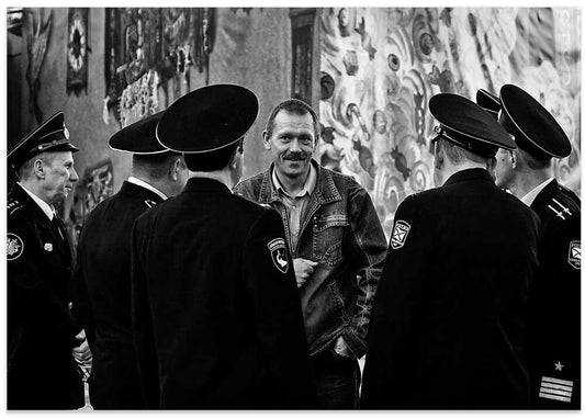 Smiling Man Among Uniforms